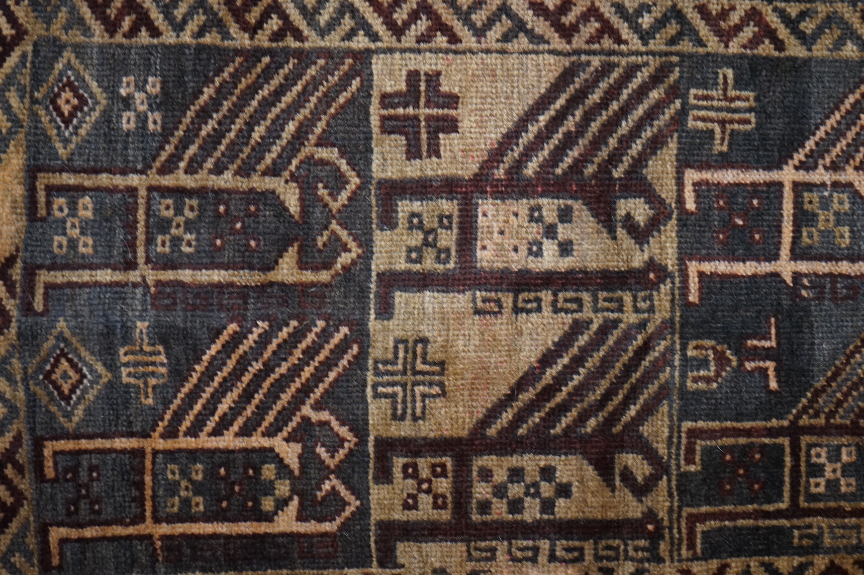 A small brown and red ground rug, 86cm wide